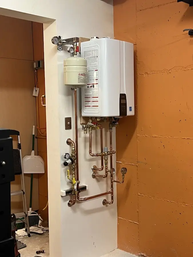 Plumbing technician inspecting water heater connections in Cambria